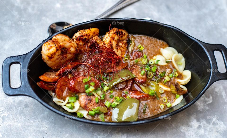 A  freshly made bowl of a seafood medley with sausage and noodles 