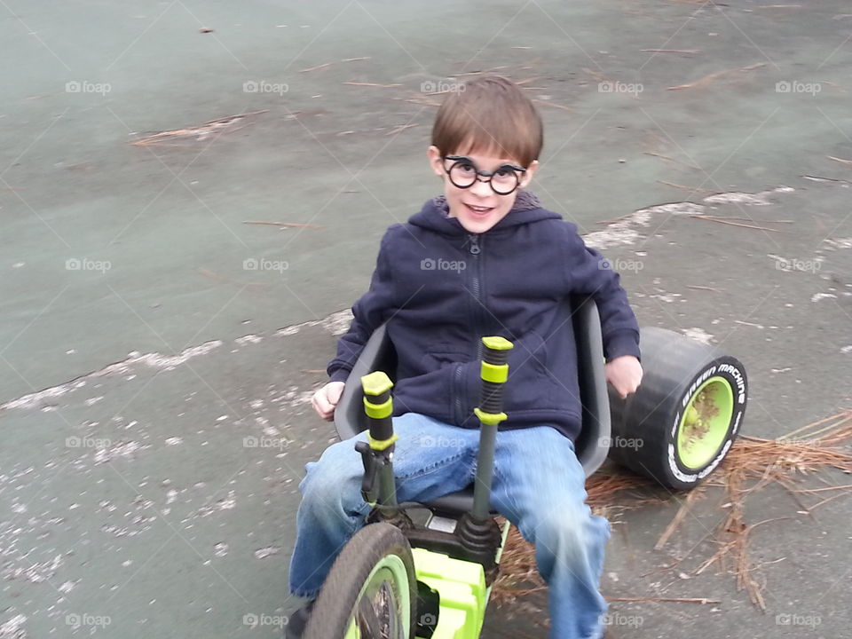 Little boy on green machine three wheeler.