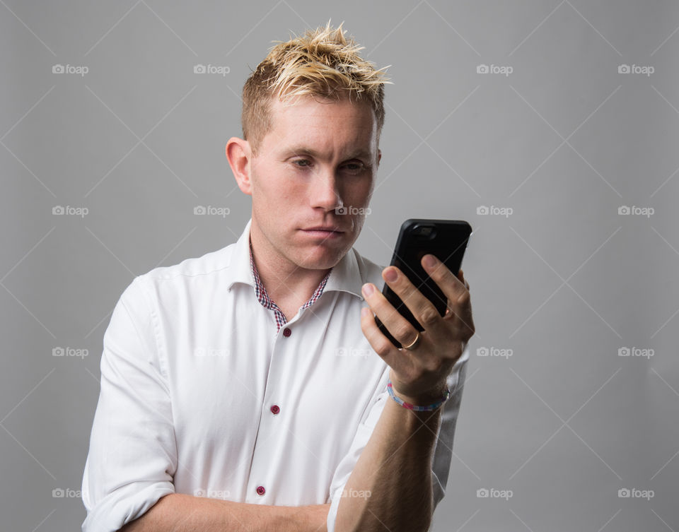 Man scrolling social media on his cellular phone.
