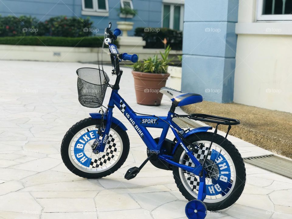 The blue bicycle stands near the blue and white combination wall