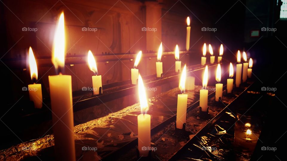 row of candles lit in church