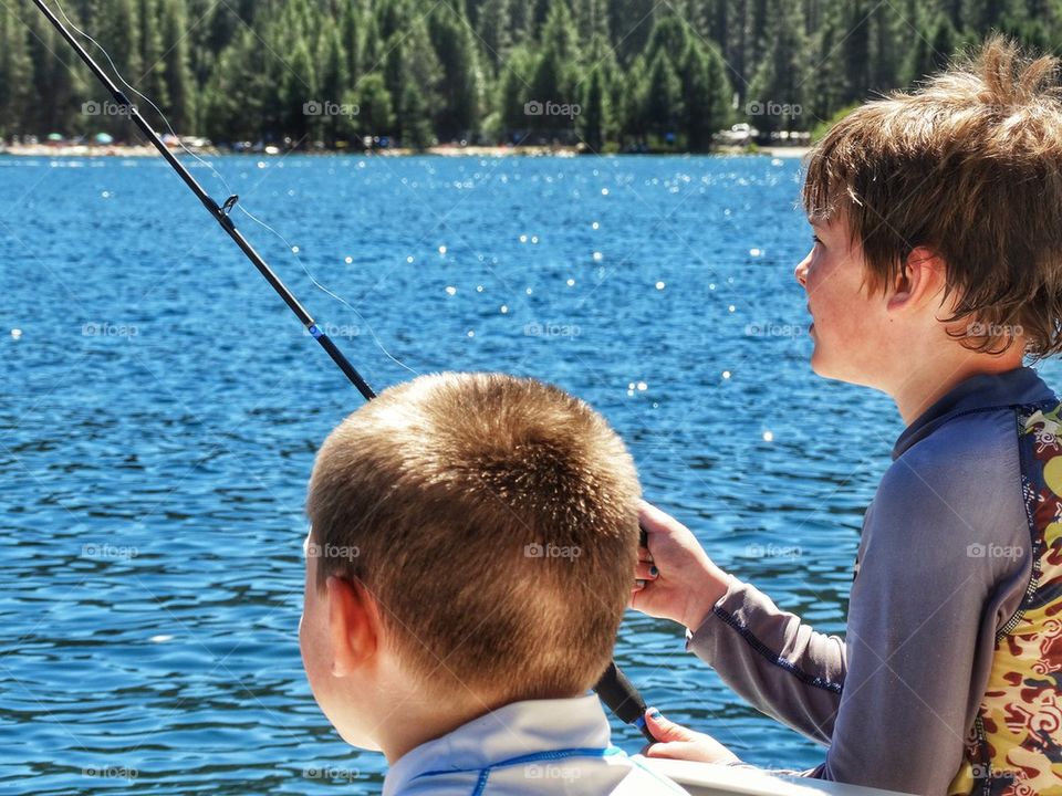 Young Brothers Fishing On A Lake
