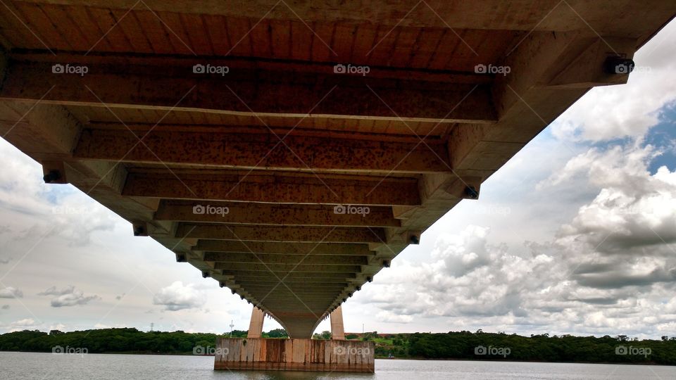 Ponte sobre um rio, suspensa, de concreto e cabos. Divisa de Estados. MS e MG, Brasil.