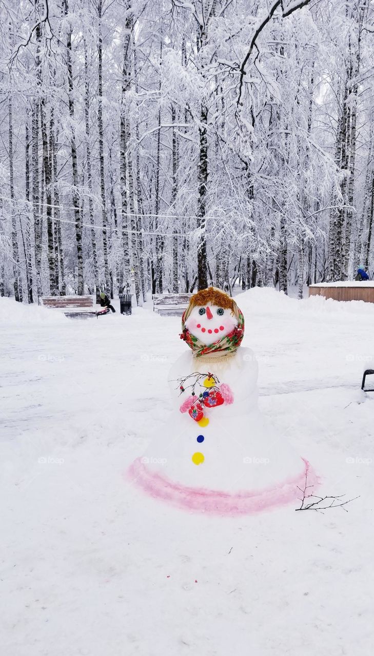 Snow woman greets everyone with a smile in the city park