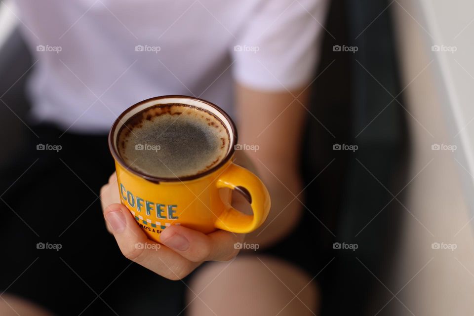 One person holding a cup with coffee.