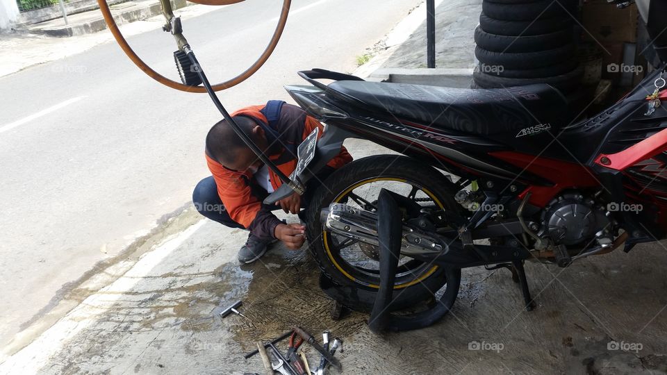 a mechanic who is repairing a motorbike