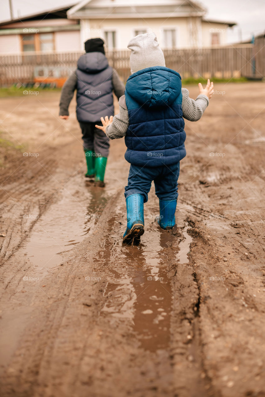 boys run through the puddles