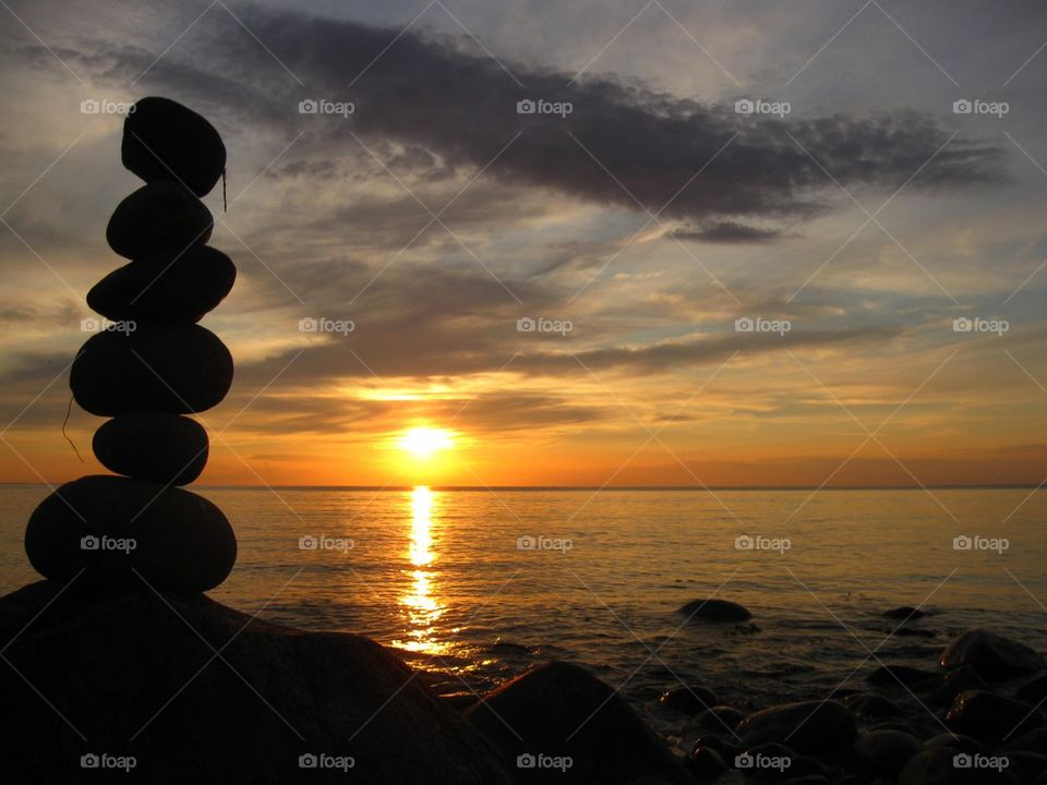 Stack of pebble at seaside during sunset