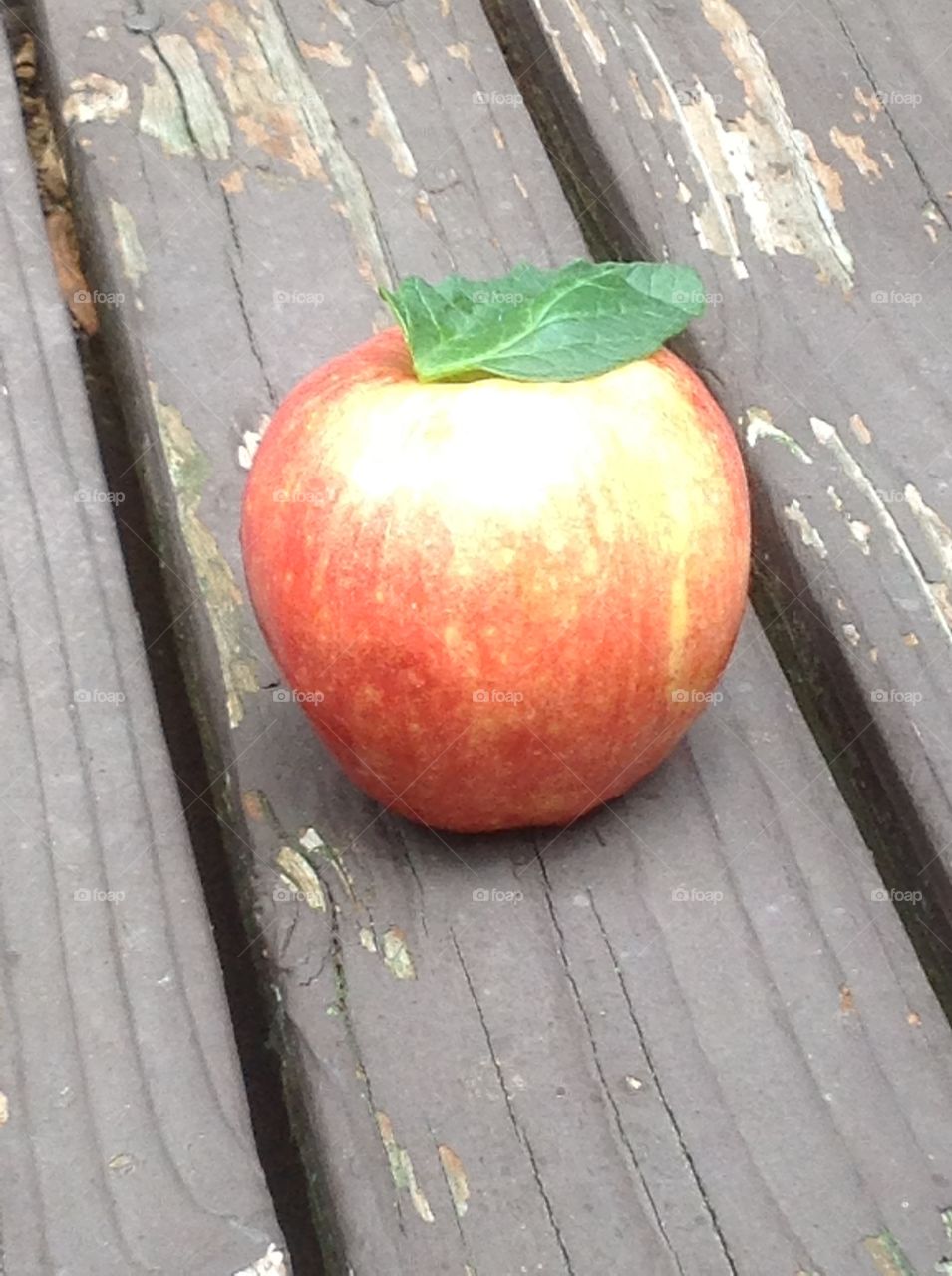 An apple on the deck outside.