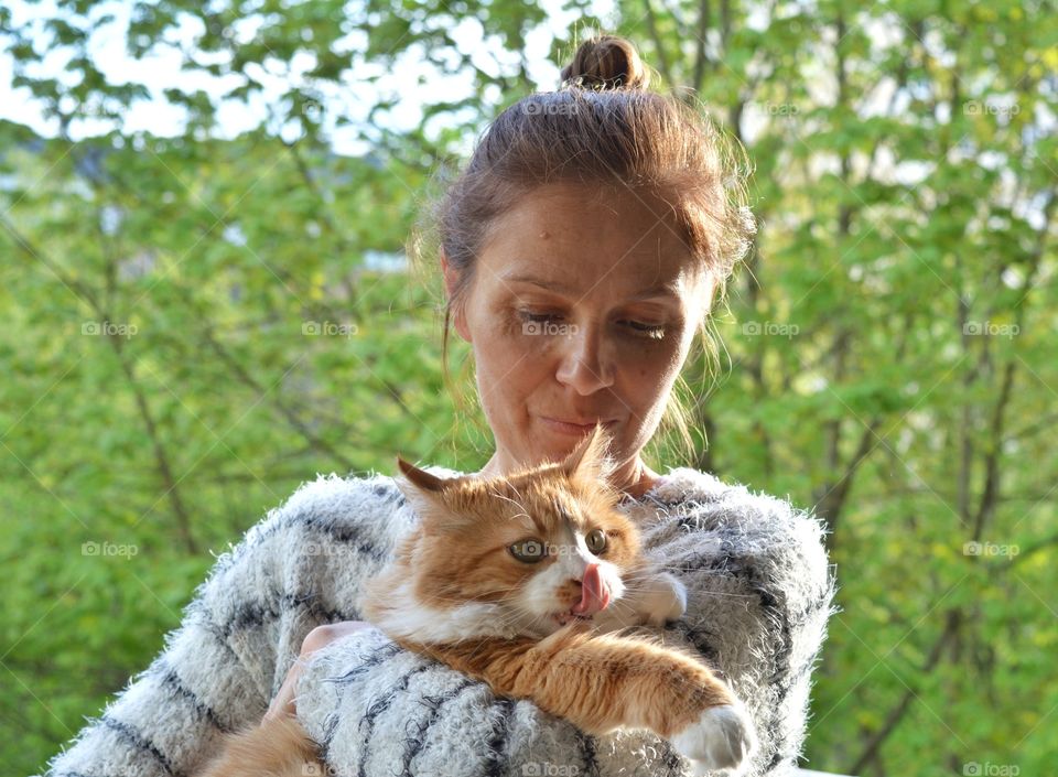 woman and ginger cat family relaxing, green background, love pet