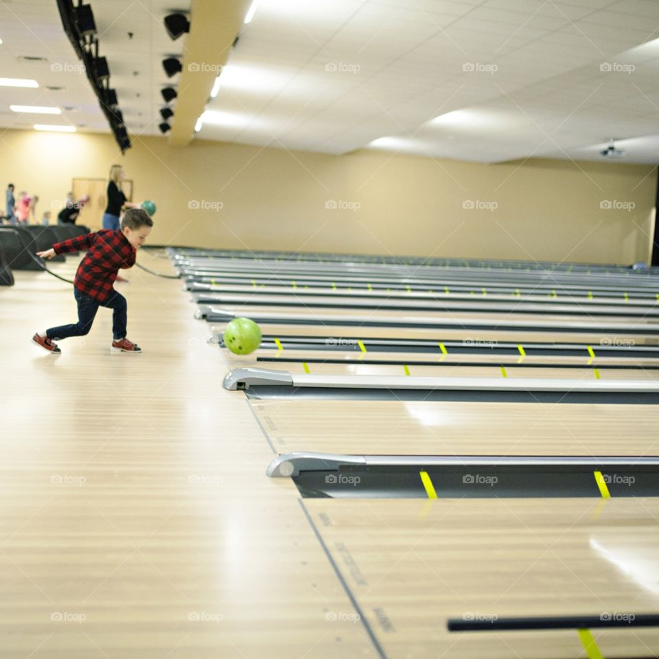 Kids bowling at a bowling alley 