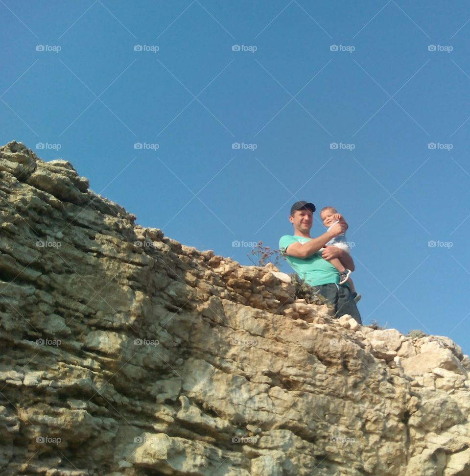 father and child on a stone rock