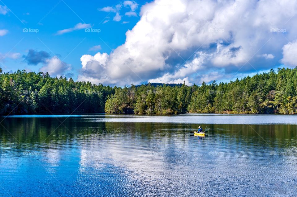 Fishing in a small boat in the middle of a quiet peaceful lake - very relaxing hobby