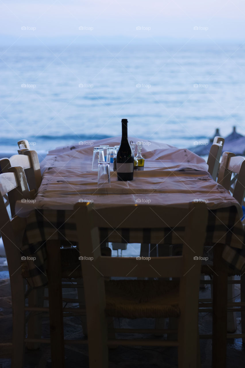 dinner table at sunset. dinner table set with vine bottle at sunset