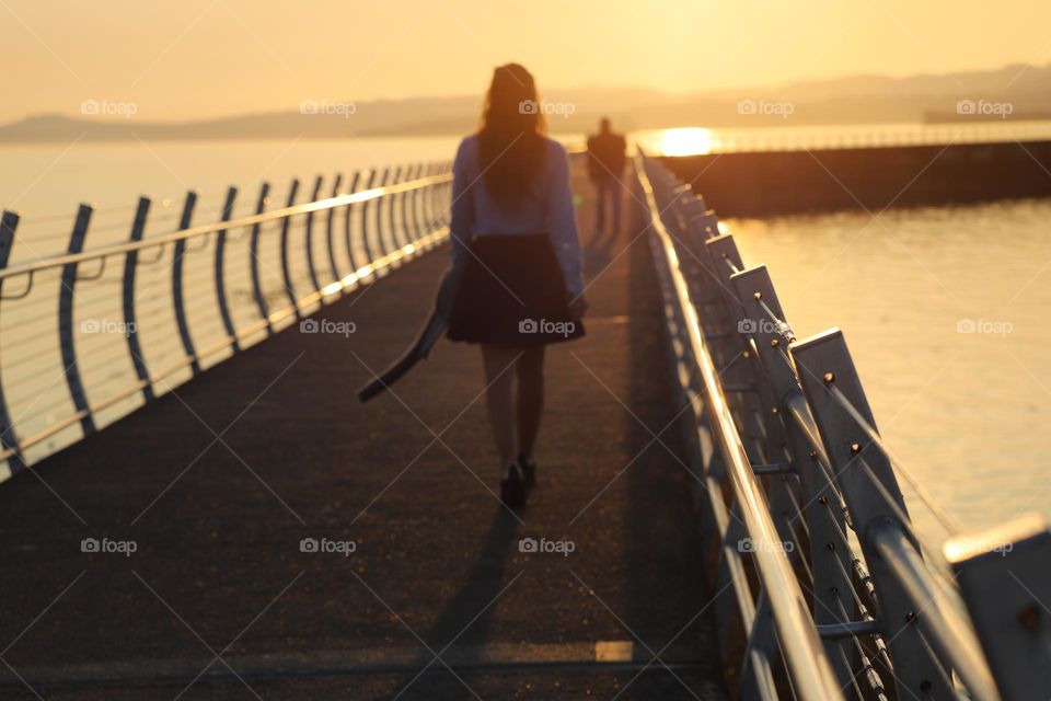 Walking on breakwater during golden hours 