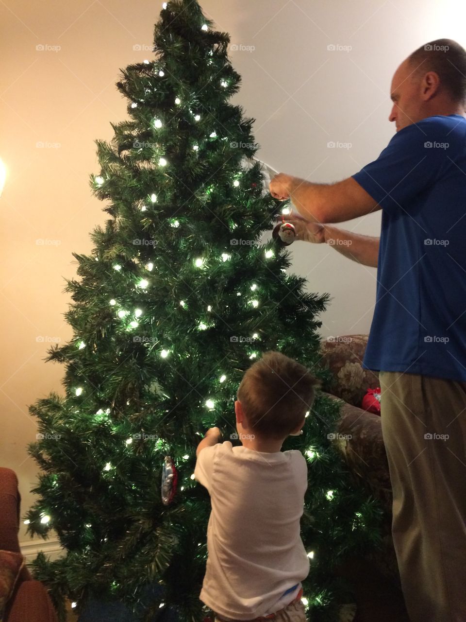 Daddy and son decorating the Christmas tree
