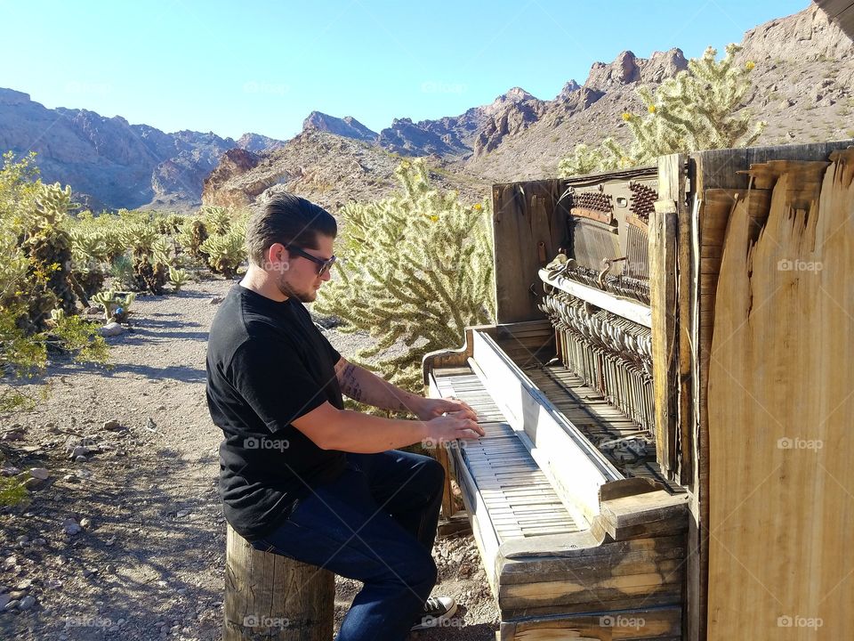 man playing old woodend abandoned piano.