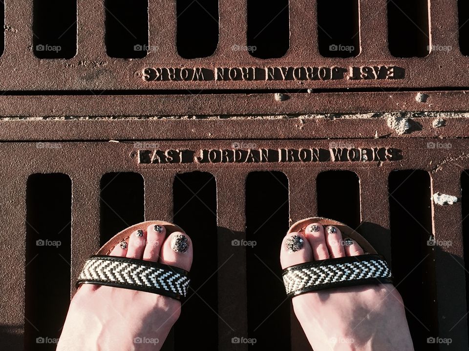 Patterned shoes, textured nails, and rusty drain