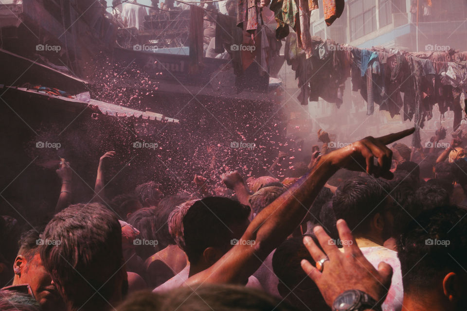 People throw pink powder in a crowded square during Holi festival in Pushkar, India.
