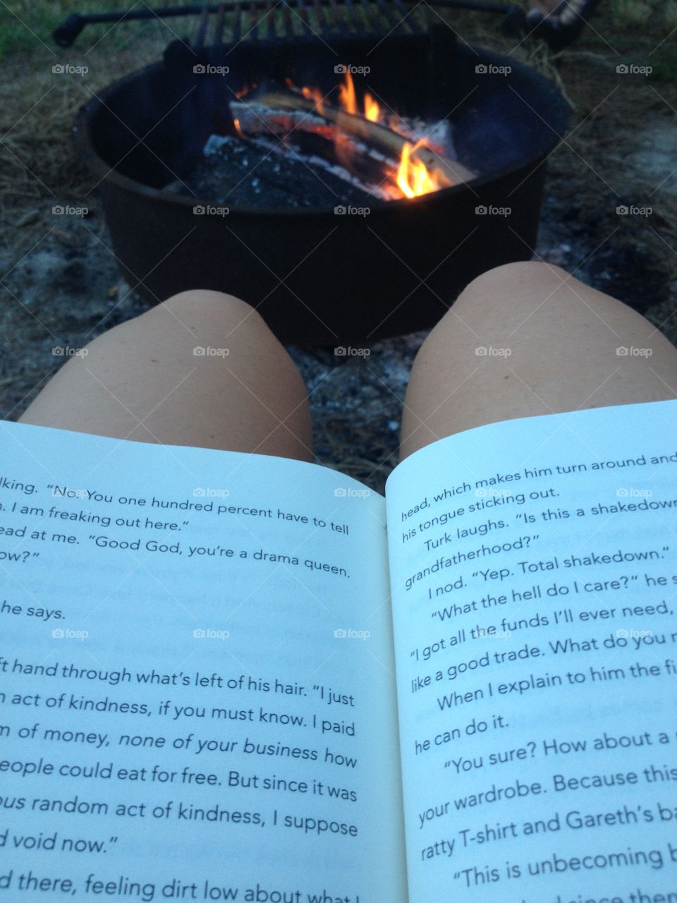 Reading a book by a campfire 