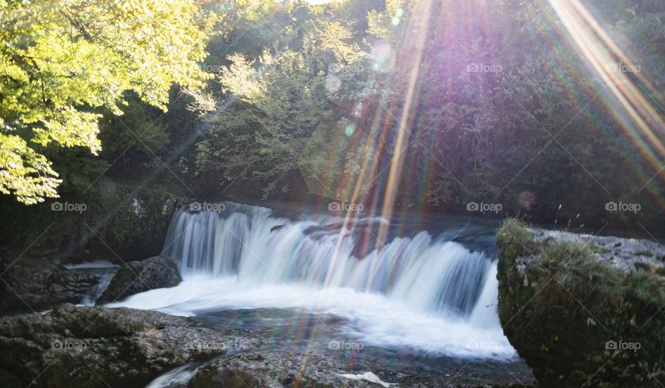 Sun light beam over waterfall In Georgia 