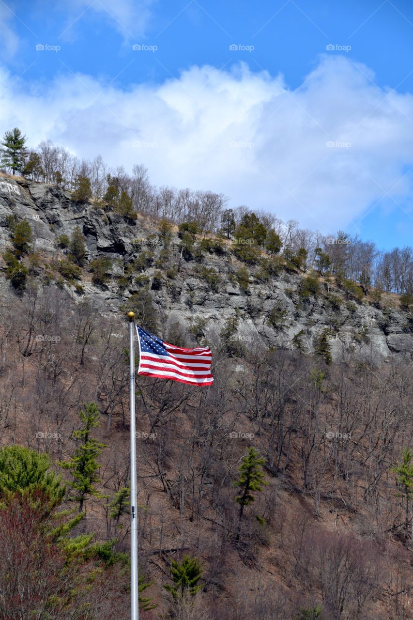 Flag flying at full mast in the mountains of the Poconos small town Milford PA