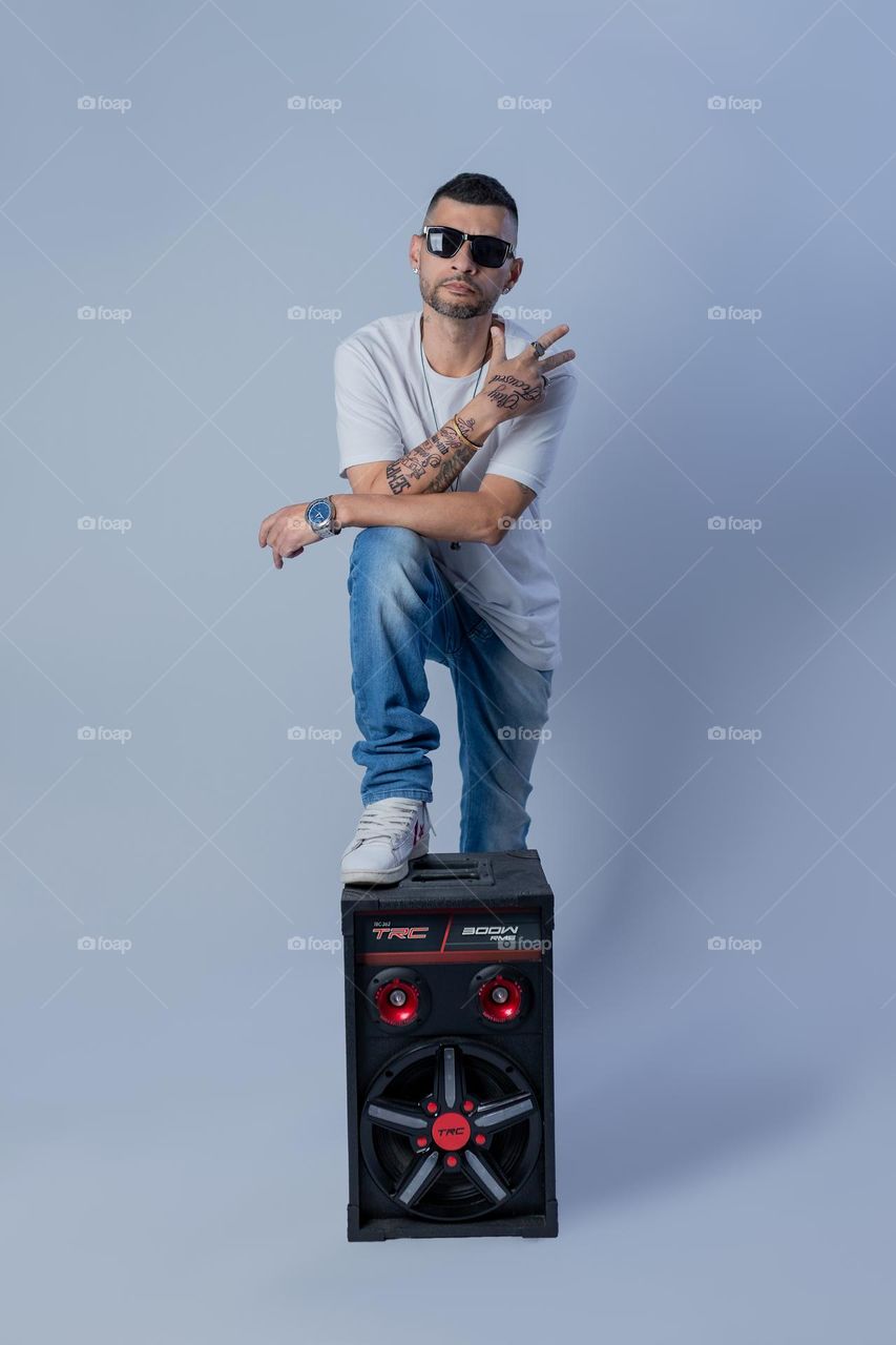Rapper tatuado e caixa de som