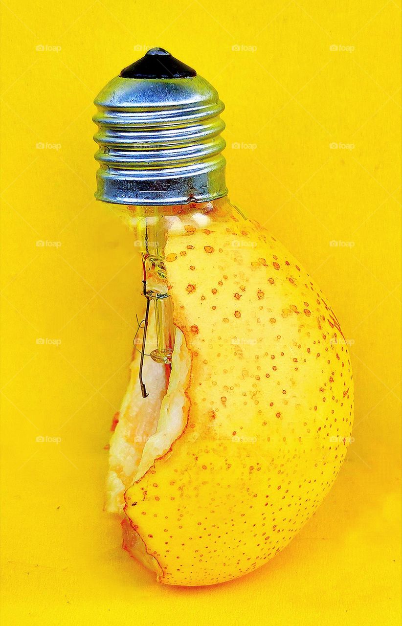 Yellow. On a yellow background is a yellow bitten off pear, into which a light bulb is inserted. The similarity of the shape of a light bulb and a pear