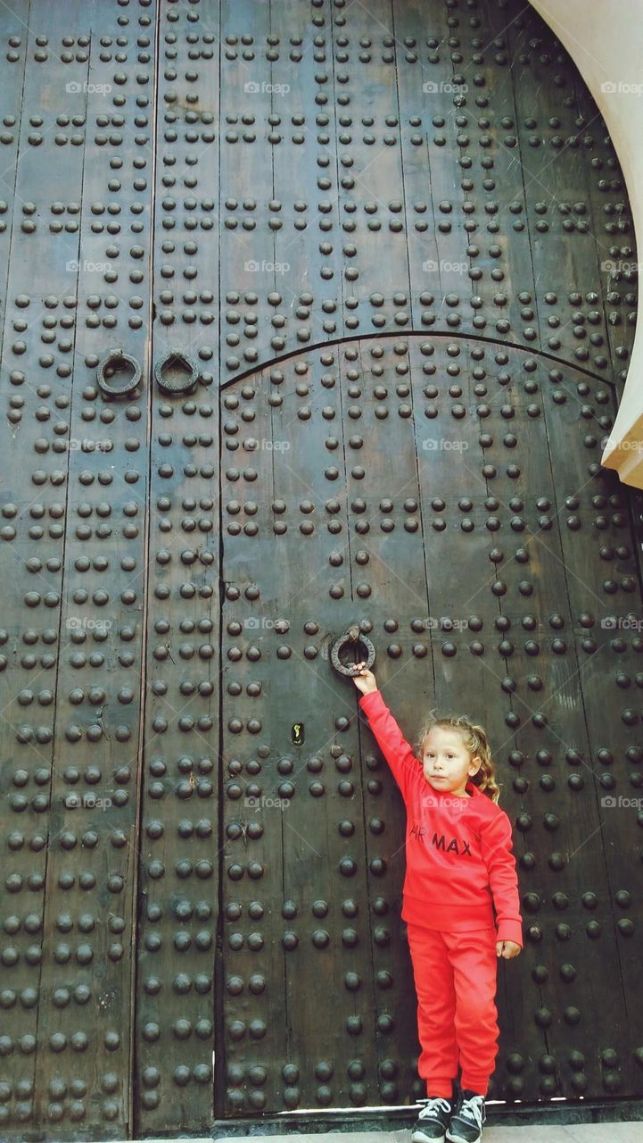 A little girl stands by the oldest door of a school of education. A tale connecting the past to the present.