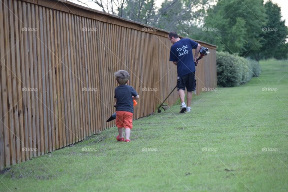 Boy helping his dad do the yard work