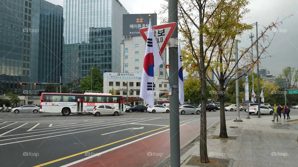city street in Seoul South Korea with national flag displayed.