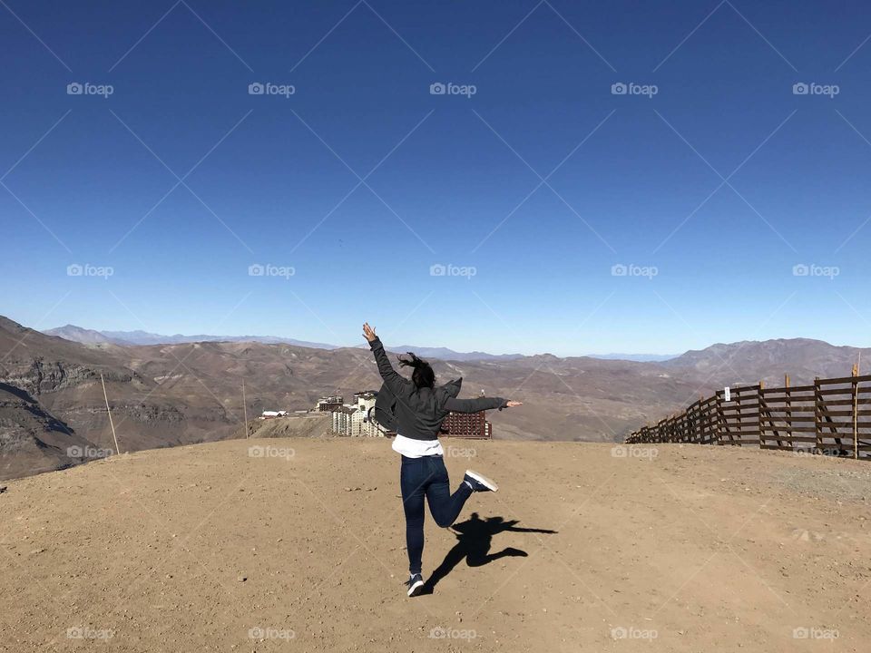 Valle Nevado, Santiago. A jump that demonstrates the happiness of being able to visit new places. Mountains in the “snowy valley” without snow, still an incredible sight.