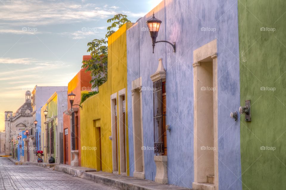 Colorful street in Mexico. Sunrise photo of a colorful street in Mexico. Houses are painted with many colors. Old style street lights are still on