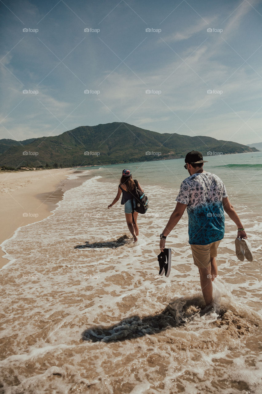 boy and girl walk along the beach