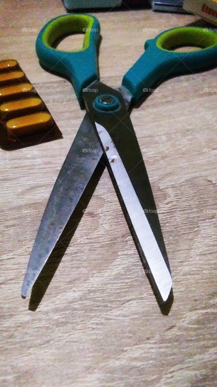 scissors and medicine on wooden table