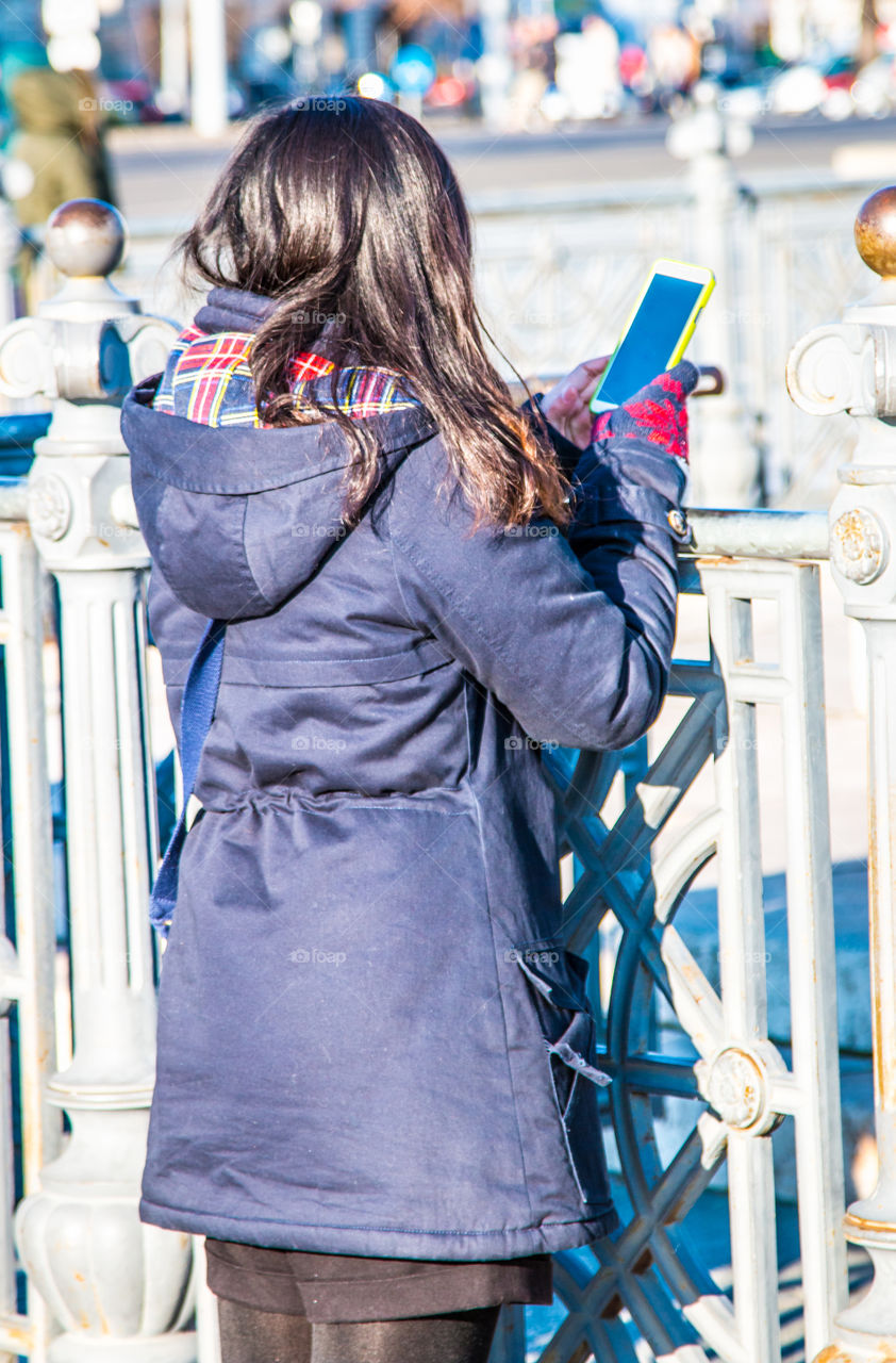 Young Woman On The Street Checking Her Smartphone
