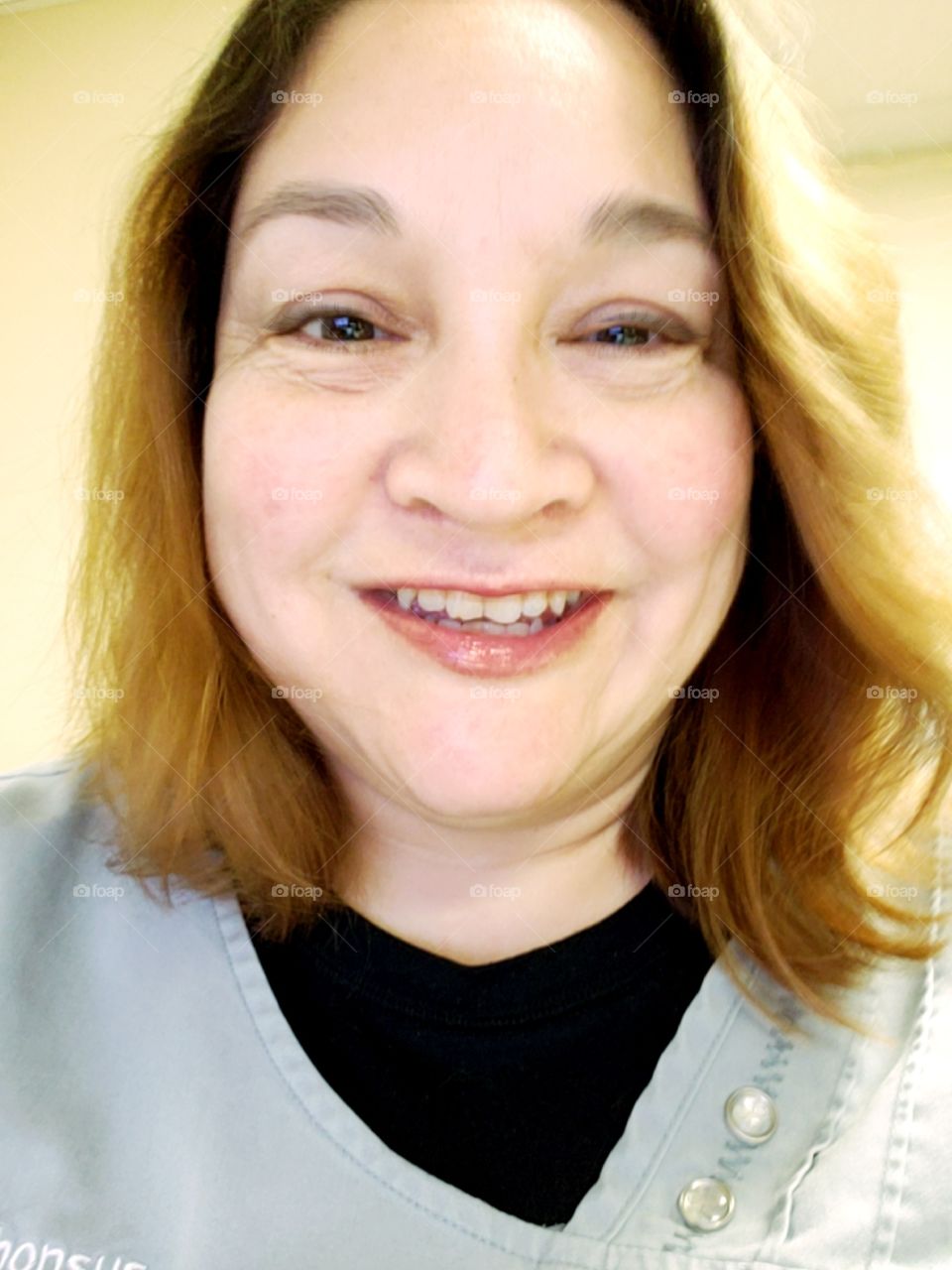selfie smiling woman wearing medical scrubs
