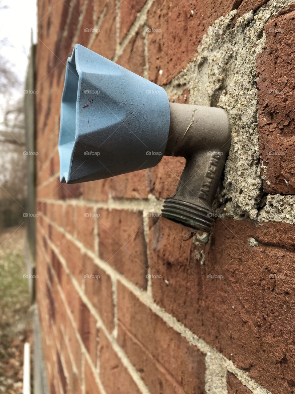 Blue outdoor spout on brick building