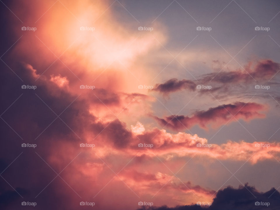 Glowing pink cloudscape during romantic sunset.