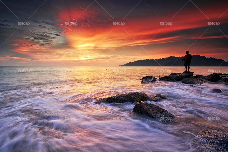 Beautiful sunset at the beach with motion waves