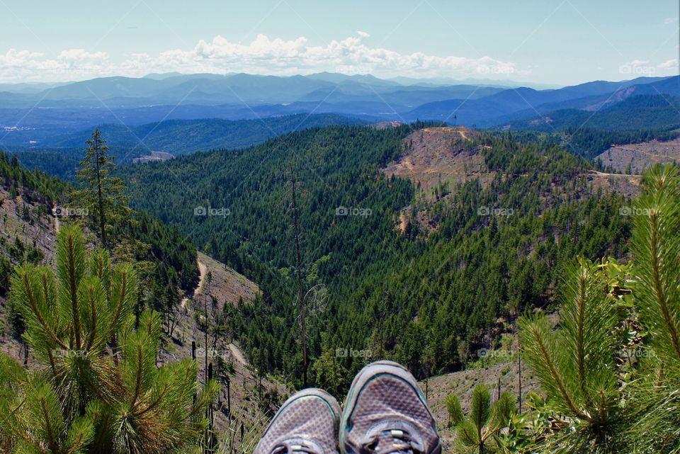 Landscape in Merlin, Oregon USA with women’s sneaking hanging off the edge of a public mountain