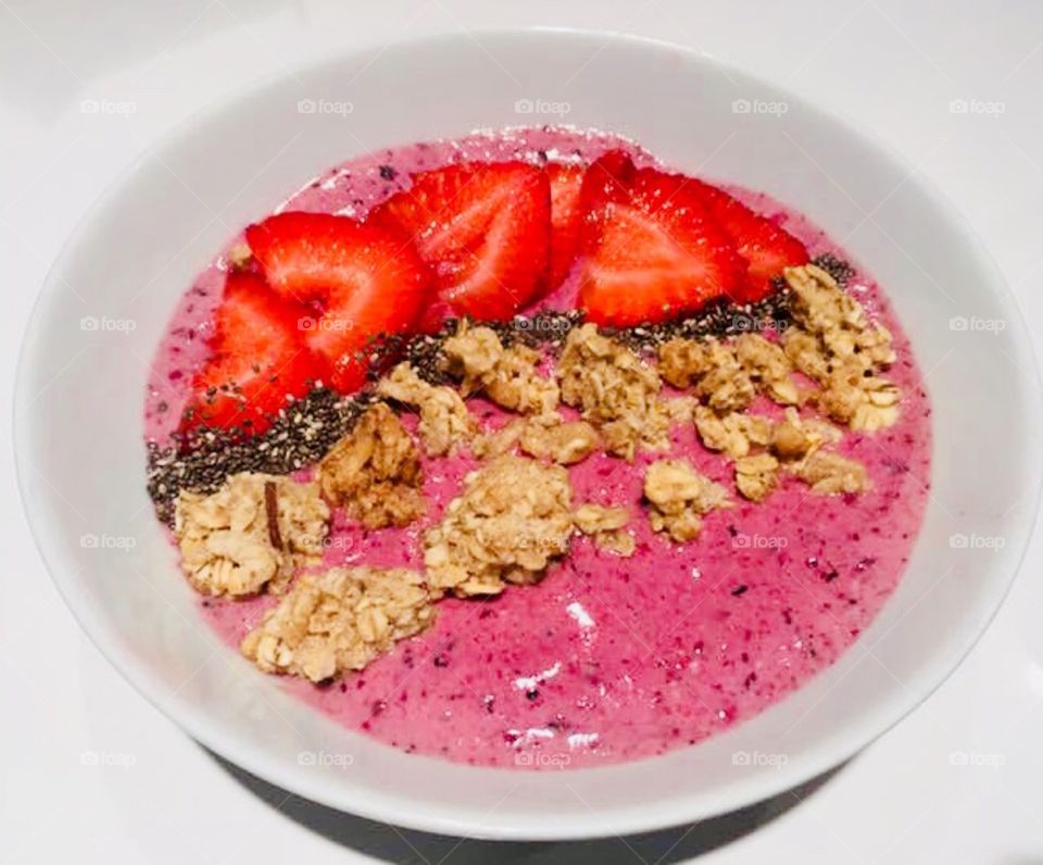 Smoothie Bowl with chia and strawberries and granola.