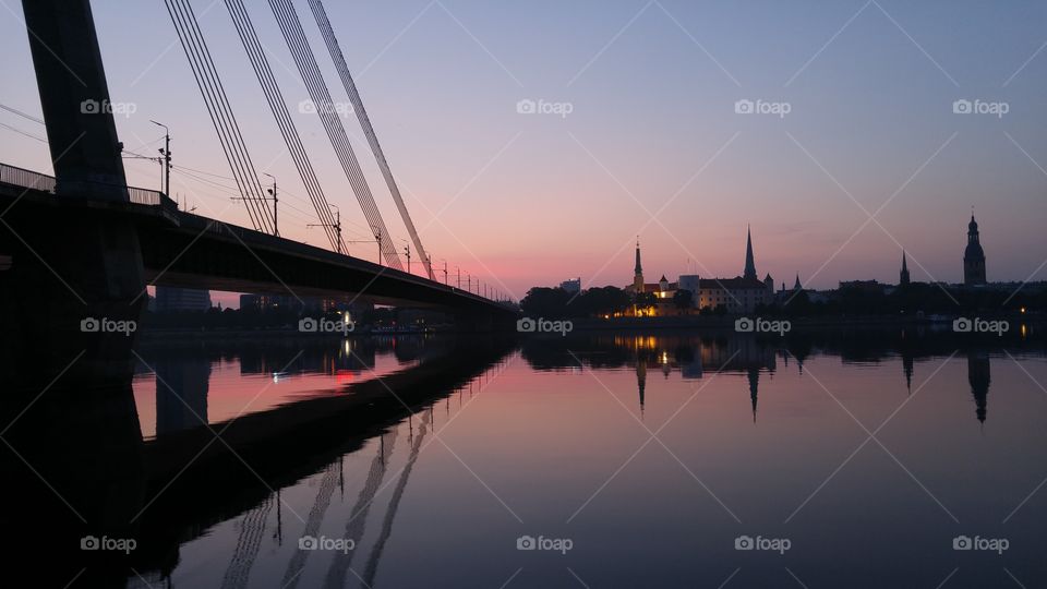 A beautiful sunset over city panorama with river and bridge in Riga, Latvia