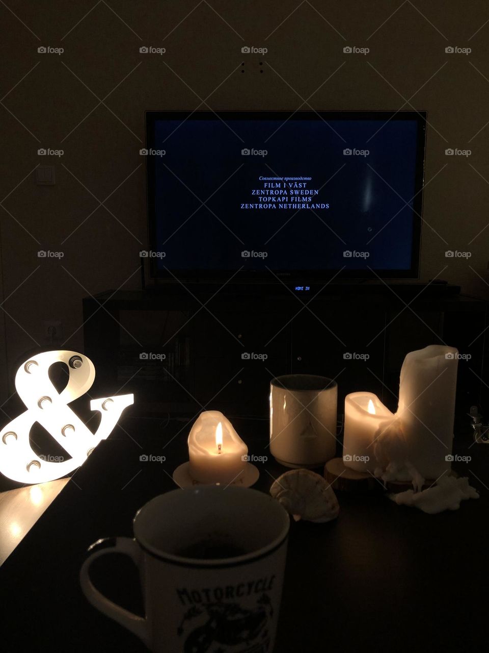 Evening at home, cozy watching a movie with candles and a letter with light bulbs 