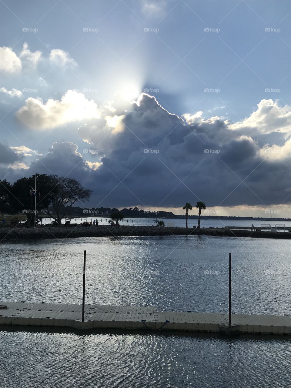 Sun trying to hide at sunset behind huge storm cloud