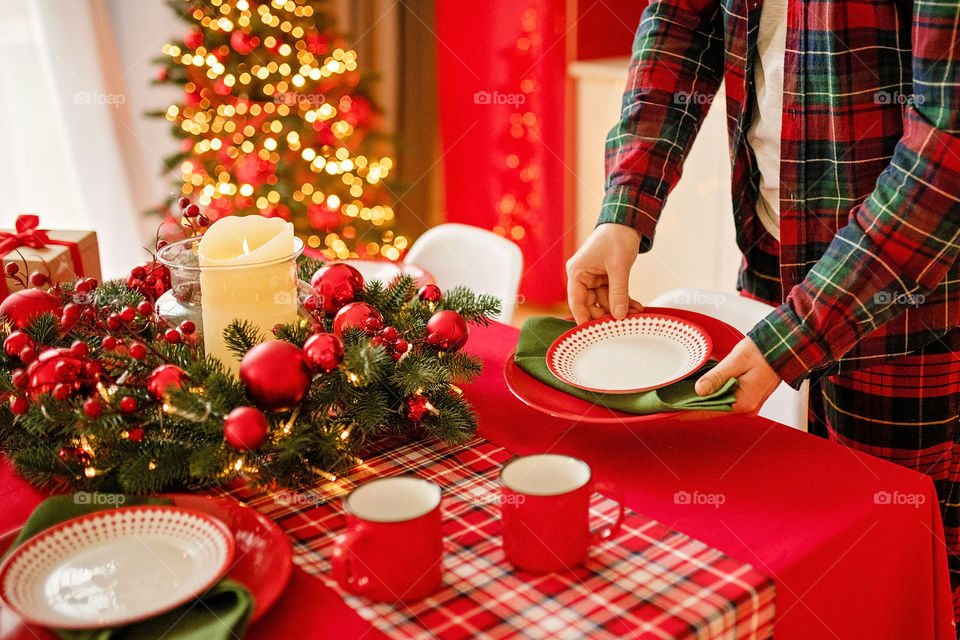 man sets a beautiful decorated winter table for a festive dinner.  Merry Christmas and Happy New Year.