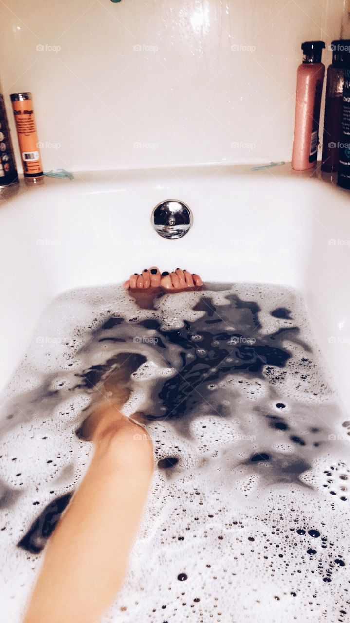 A girl in a relaxing bubble bath.