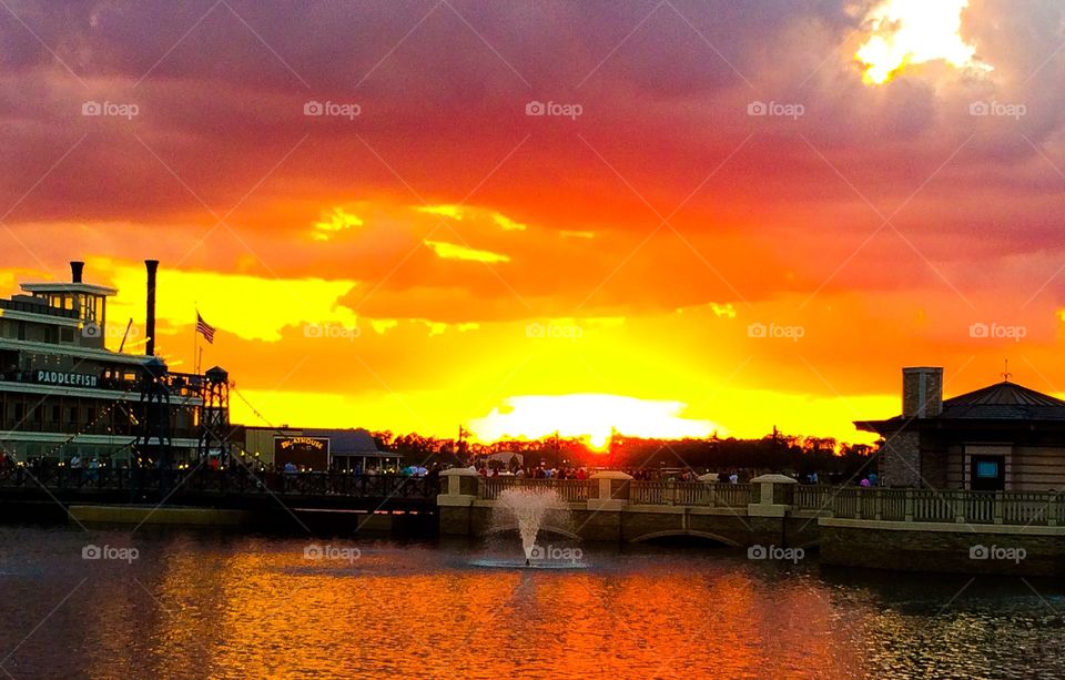 Sunset over the lake with a fountain 