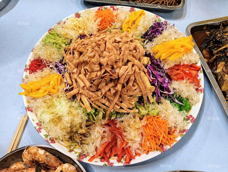 Overhead view of a Prosperity Toss Salad (Yu Sheng) on the table.