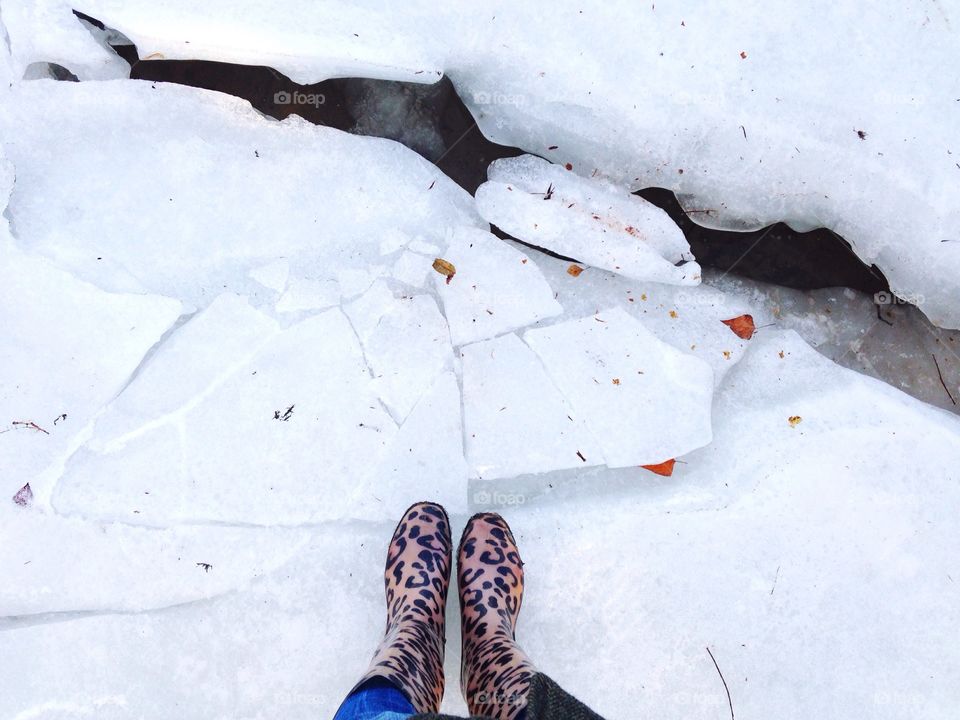 Feet at the frozen winter river 